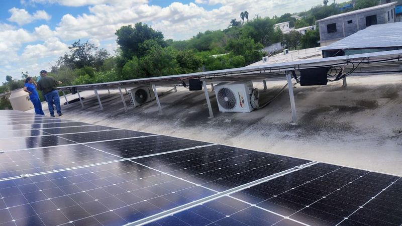Arreglo de paneles solares en la azotea con el equipo de trabajo