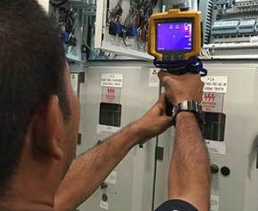 Técnico revisando un tablero con cámara termográfica